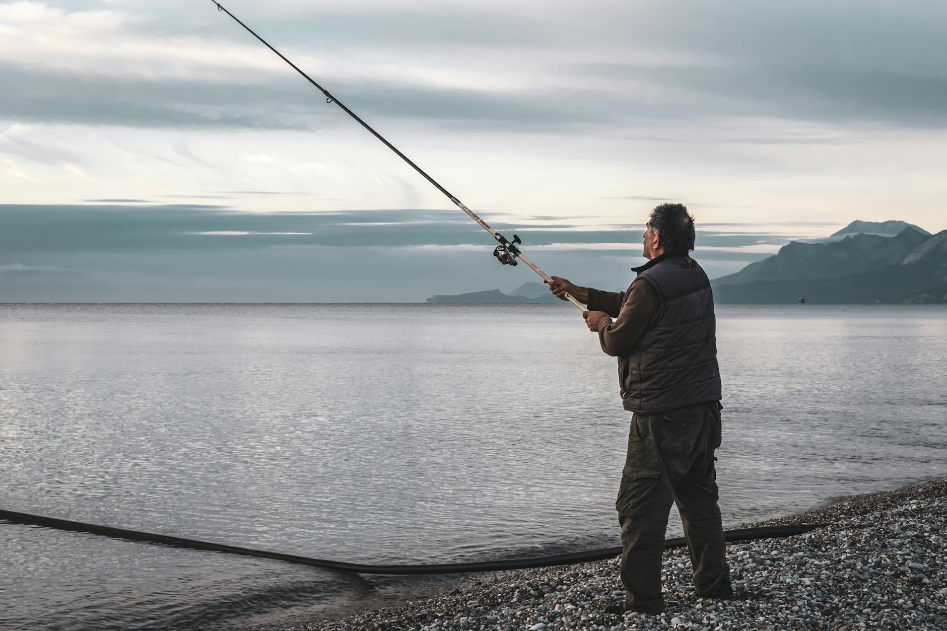 Pescador practicando pesca deportiva en un río español al amanecer